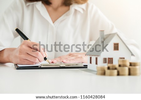 Business woman signing contract to buy house, insurance or loan real estate on table.