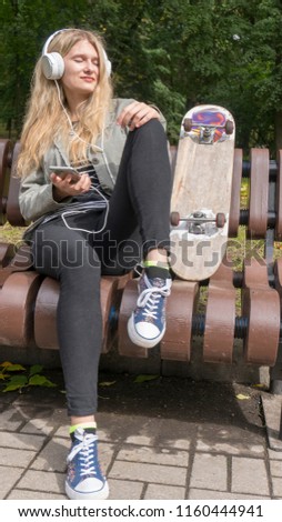 Beautiful girl on skateboard in sunny weather