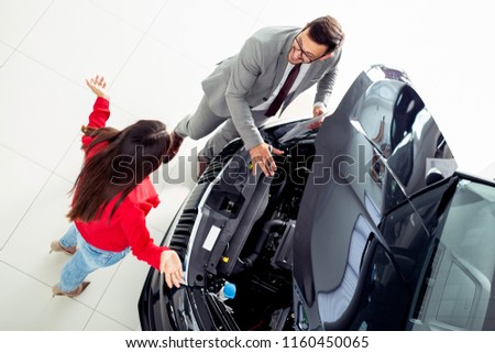 Top view photo of young male consultant and buyers signing contract for new car