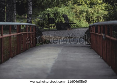 Moody, Dark Photo of the Bridge in a Park, Between Woods - with Focused Park Benches in the Background - Desaturated, Vintage Look with Space for Text, Autumn day