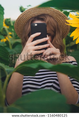 woman making pictures on her mobile phone. sunflower field. lifestyle