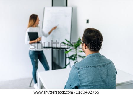 Professional tutor conducting private lesson on flipchart to a student. Royalty-Free Stock Photo #1160482765