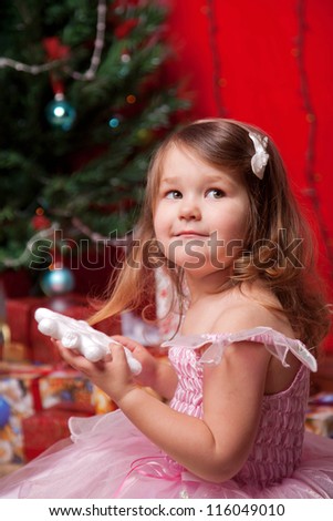 Little girl waiting for miracle under the Christmas tree in the new year or christmas.