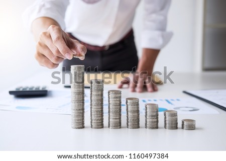 Business accountant or banker, businessman calculate and analysis with stock financial indices and putting growth stacking coin and financial costs wisely and carefully, investment and saving concept. Royalty-Free Stock Photo #1160497384