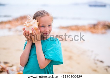 Portrait of adorable little girl with a seashell Royalty-Free Stock Photo #1160500429