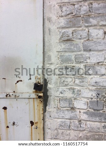 An old lock and chain on a wooden door at grey background