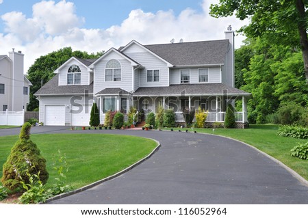 Large Suburban McMansion Home with blacktop circular driveway in residential neighborhood in USA Royalty-Free Stock Photo #116052964