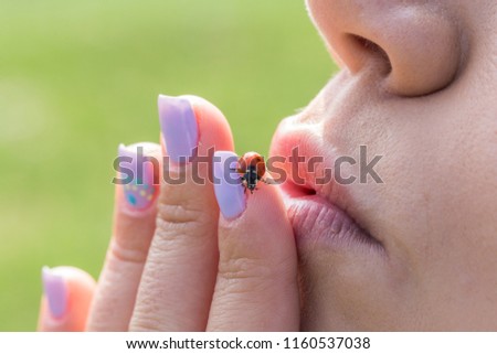 Woman trying to kiss a ladybug