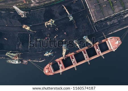 The Cargo Ship is in the Port Pier at the Loading of Coal at Sunset. Aerial View from Drone. Location Kandalaksha Town, Cola Peninsula, Russia Royalty-Free Stock Photo #1160574187