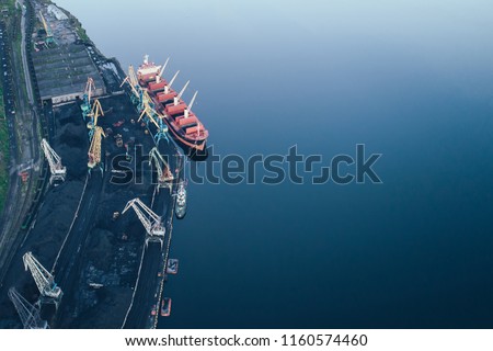 The Cargo Ship is in the Port Pier at the Loading of Coal at Sunset. Aerial View from Drone. Location Kandalaksha Town, Cola Peninsula, Russia Royalty-Free Stock Photo #1160574460
