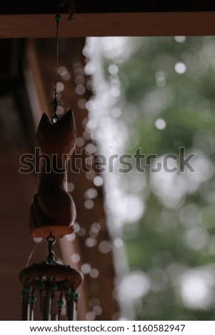 Close​ up​ wooden​ cat​ mobile​ hanging​ and​ white​ bokeh​ on​ green​ background​