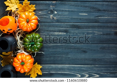 colorful Halloween decoration with pumpkins, cauldrons, leaves, lanterns on the dark wooden background. Flat lay, copyspace