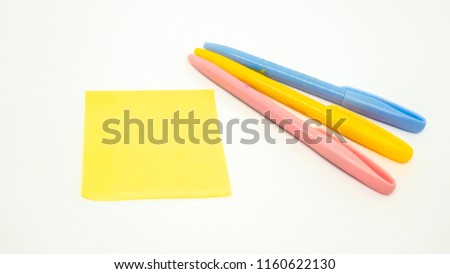 Yellow paper and pen on white background.