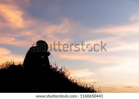 silhouette of woman are using ideas on top of a hill in the sunset