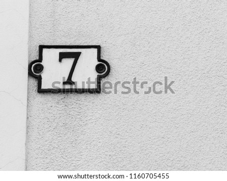 number seven on a stone wall for the indication of house number