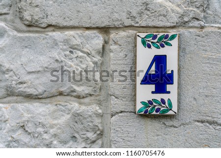number four on a stone wall for the indication of house number