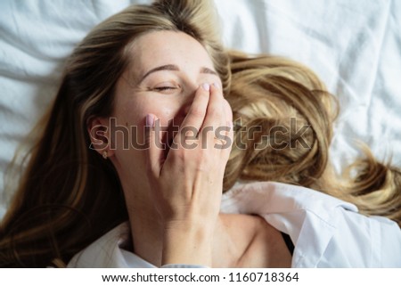 Young woman with blonde hair lying on the bed