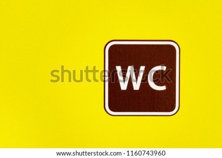 The sign a toilet on a yellow background. Copyspace. abbreviation WC. Symbol of the place bathroom