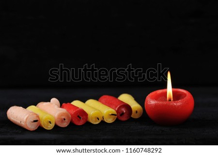 colorfull cinder from candles on a black wooden rustic background - place for text