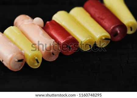 colorfull cinder from candles on a black wooden rustic background - place for text