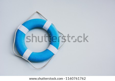 blue and white safety torus or lifebuoy hanging on white wall background, copy space Royalty-Free Stock Photo #1160761762