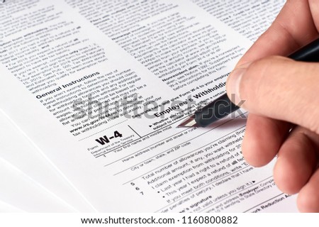human hand fills out the W-4 tax form Royalty-Free Stock Photo #1160800882