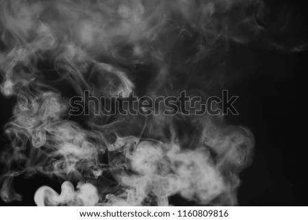White smoke on a black background. Texture of smoke. Clubs of white smoke on a dark background for overlay
