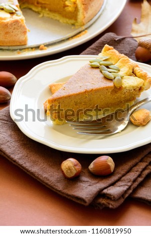 Homemade pumpkin pie with cinnamon on brown paper background. Thanksgiving day or Halloween holiday concept