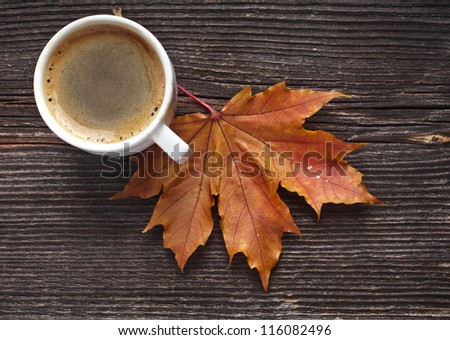 coffee cup on the autumn fall  leaves and wooden surface background