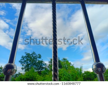 
Pictures taken near an aluminum cage and with a sky and tree background.