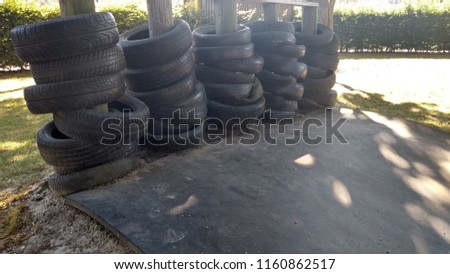 Stack of car tires used for skater barrier in a playground