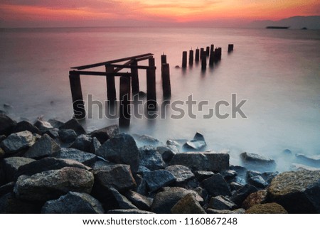 abandon jetty by seaside during sunset, slow shutter speed applied