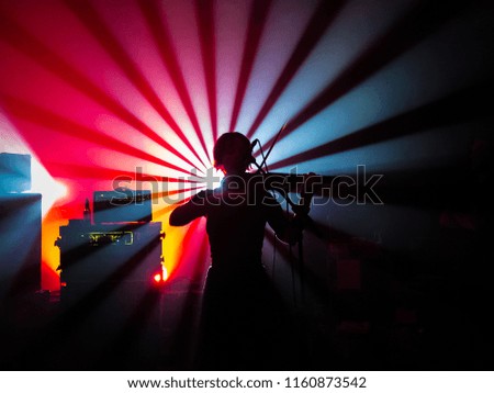 Violin player in colorful rays of light