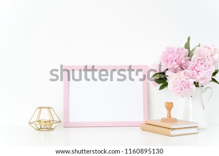 Pink landscape frame mock up with a pink peonies, candle and stamp beside the frame, overlay your quote, promotion, headline, or design, great for small businesses, lifestyle bloggers