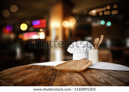 Table background with free space for your decoration . Cook hat and dark interior background. 