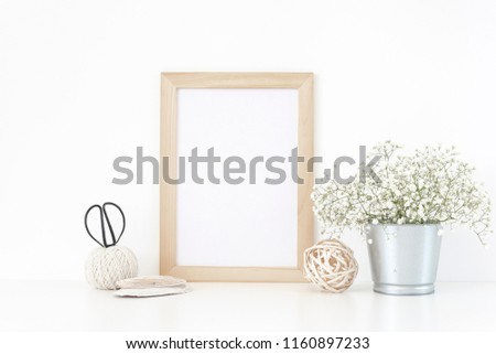 Wood frame mockup A4 in interior. Tin can with bouquet of white flowers . Frame mock up poster or photo frame for bloggers, social media, lettering, art and design. Background.