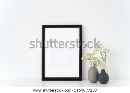 Elegant black portrait a4 frame mock up with a Aegopodium podagraria in little vases. Mockup for quote, promotion, headline, design. Template for small businesses, lifestyle bloggers, social media