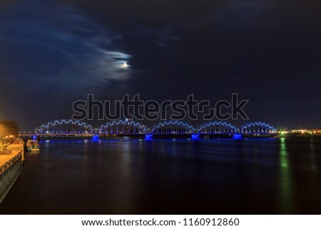 The Railway Bridge is a bridge that crosses the Daugava river in Riga, the capital of Latvia. Night illumination on the bridge in the full moon.