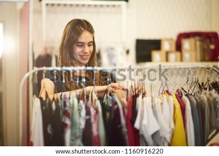 Portrait of wooman choosing clothes in the store.
