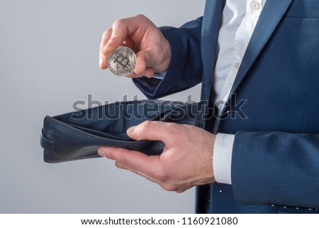 Businessman holding bitcoin isolated on a white background. Silver bitcoin coins in man hands. Virtual currency. Crypto currency. New virtual money. Opened wallet.