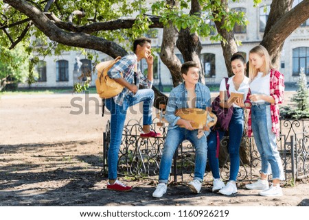 group of teenagers sitting at school garden together