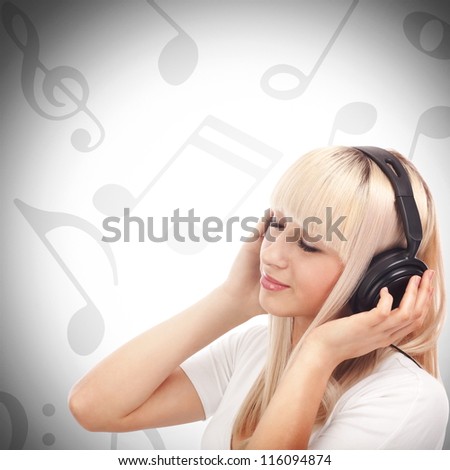 Pretty young girl enjoys listening music between musical notes