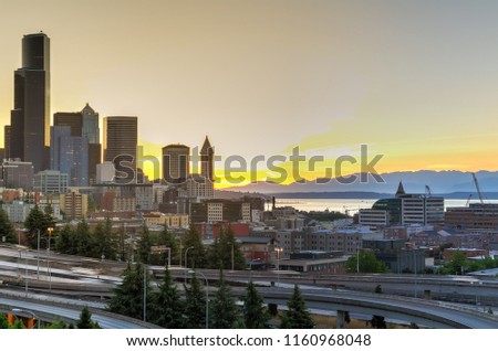 Seattle skylines and s-curved I-90, I-5 highway interchange traffic motion during sunset. Travel and transportation background, cityscape and high speed concept. View from Rizal Park