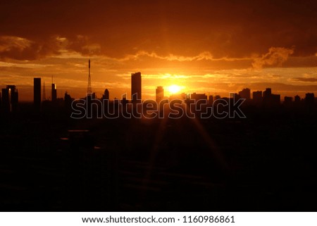 Spectacular views of the Bangkok downtown skyline with sunset. Black silhouettes against a golden sky.
