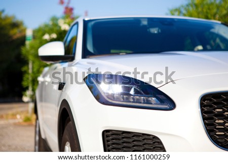 Close up Summer image in front of the luxury sport white car with trees in the back. Cars For Sale Stock. Car Dealer Inventory