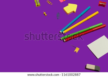 set of various school and office supplies lying on a purple background. free copyspace
