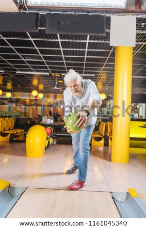 Games for adults. Delighted nice man throwing a watermelon while having fun