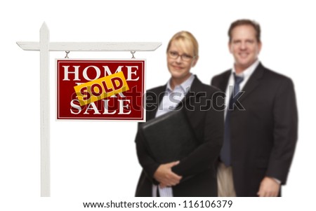 Businesswoman and Businessman Behind Sold Home For Sale Real Estate Sign Isolated on a White Background.