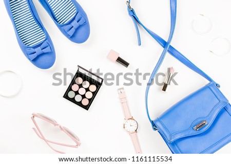 Fashion blogger workspace flat lay with navy flats, cosmetics, purse, sunglasses.