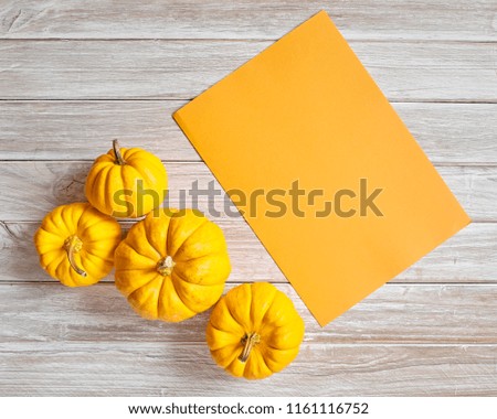 pumpkin autumn with Orange paper sheet on wooden background texture